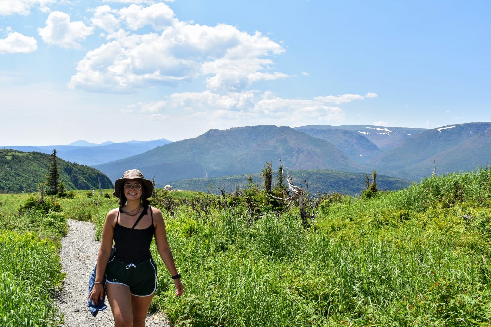 woman with a smile hiking in the mountains